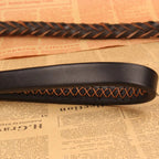 Detailaufnahme einer geflochtenen Hundeleine in Schwarz und Cognac mit sauberer Nahtverarbeitung, weicher Lederoptik und elegantem Design.