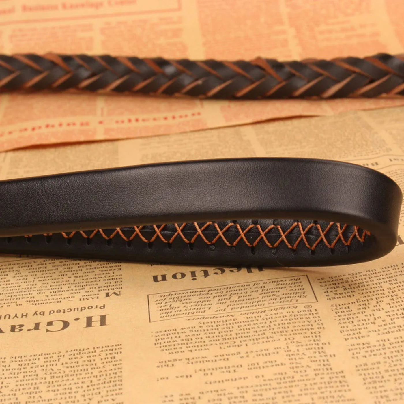 Detailaufnahme einer geflochtenen Hundeleine in Schwarz und Cognac mit sauberer Nahtverarbeitung, weicher Lederoptik und elegantem Design.