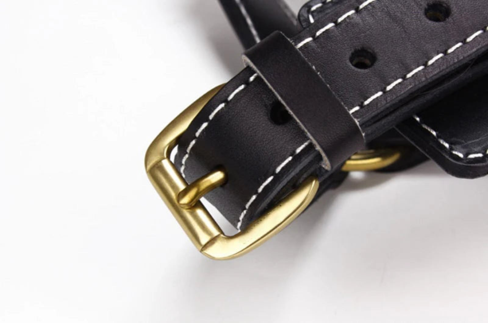 Detailaufnahme der goldfarbenen Schnalle eines schwarzen Premium Leder Hundegeschirrs von Hund & Heim mit hochwertiger Nahtverarbeitung und verstellbarer Passform